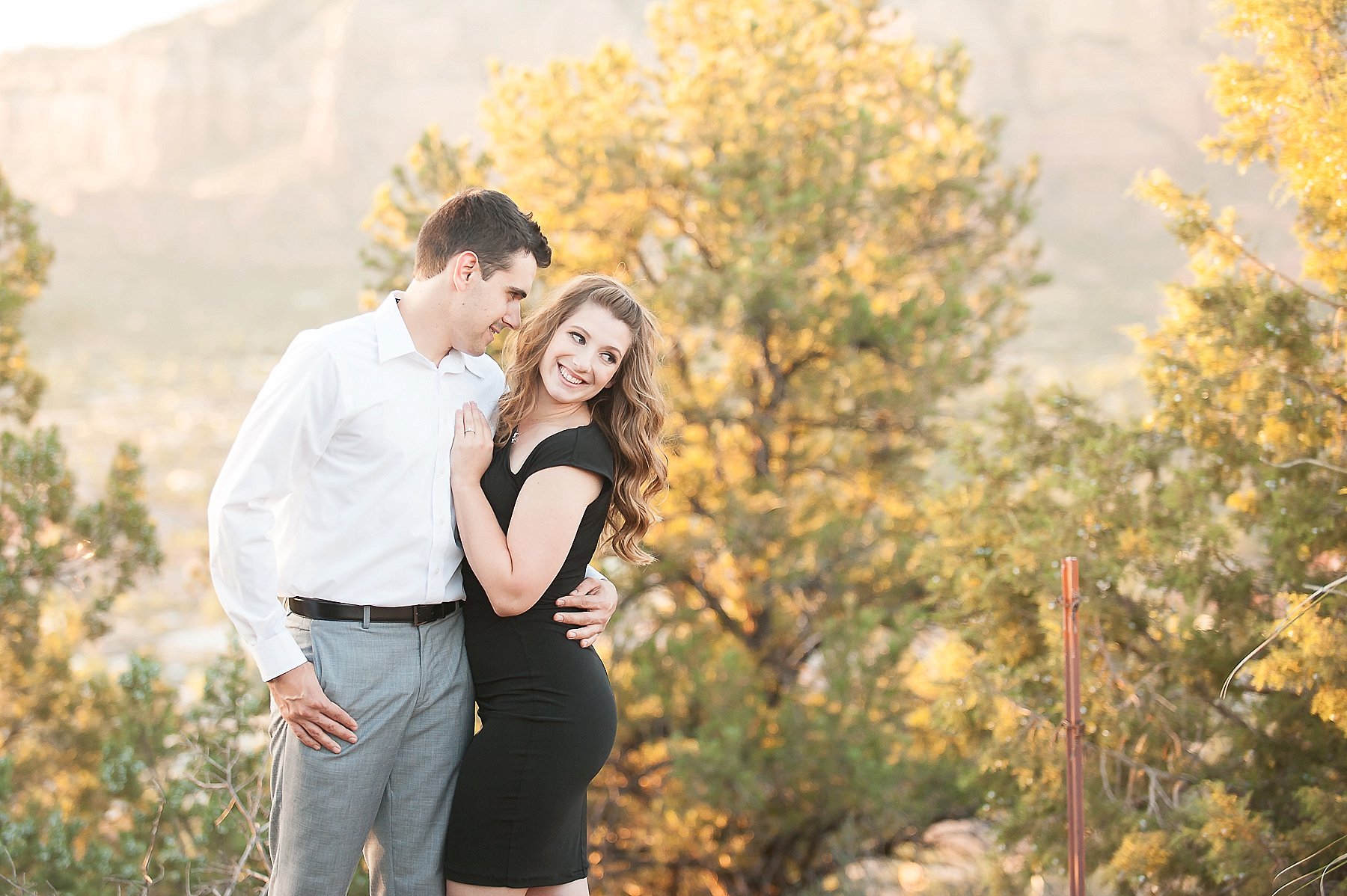 Red Rock Engagement Couple Hugging Greenery Sedona Arizona Photo