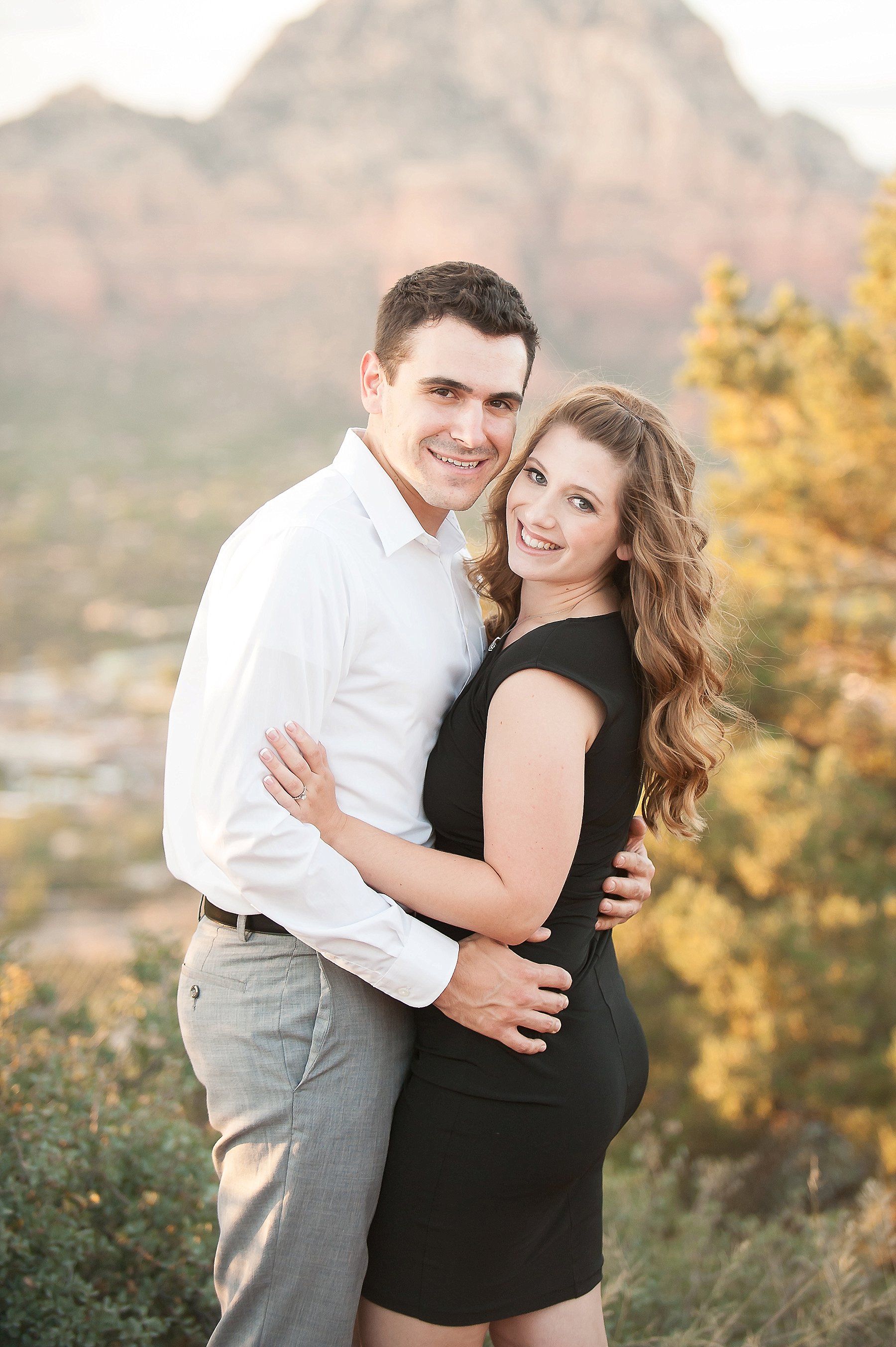 Red Rock Engagement Couple Smiling Embracing Mountain View Sedona Arizona Photo